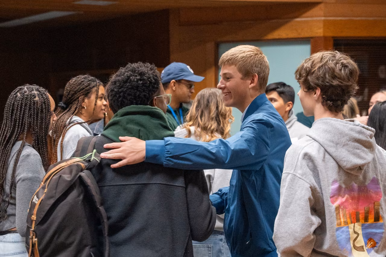 A group of alumni gathers for an embrace during the reunion.