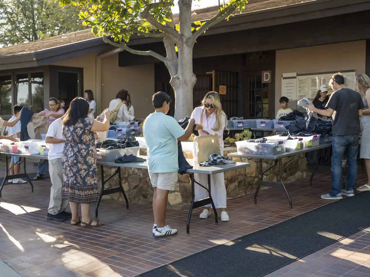 Families and students gather around outdoor welcome tables on Visiting Day.