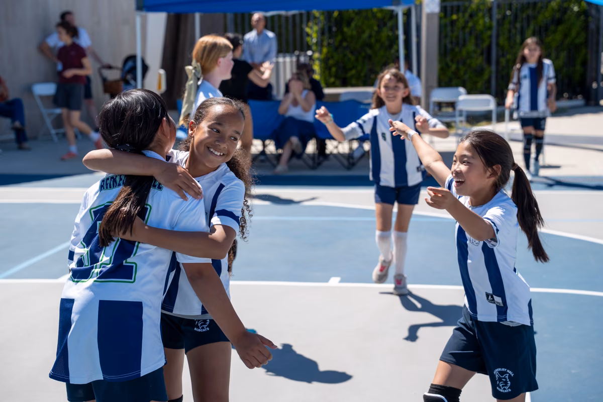 Students celebrate together on the volleyball court.